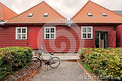 Traditional wooden house in historical area of Copenhagen, Denmark. Bicycle parked past old house on city street. Stock Photo