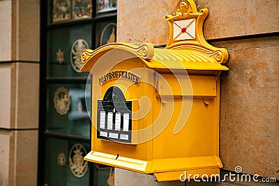 A traditional yellow letter box in Germany. Communication between people, sending letters and receiving messages. Stock Photo