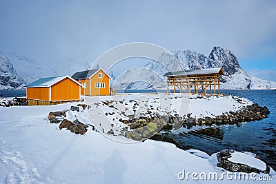 Rorbu house and drying flakes for stockfish cod fish in winter. Lofoten islands, Norway Stock Photo