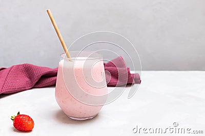 Traditional yogurt indian drink Strawberry Lassi in a glass cup on concrete neutral background Stock Photo