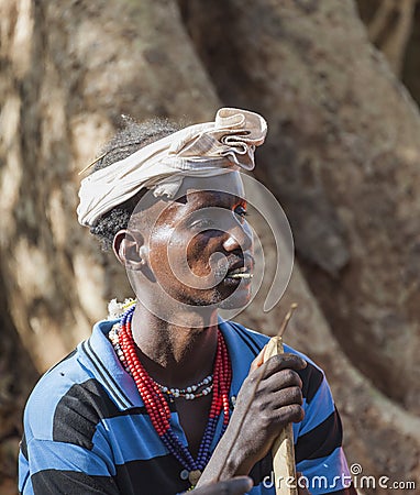 Traditionally dressed Hamar man with chewing stick in his mouth. Turmi, Omo Valley, Ethiopia Editorial Stock Photo