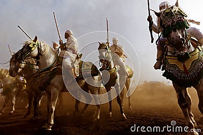 Traditionally dressed Moroccan tribals and horsemen riding the horses and fire the rifles Editorial Stock Photo