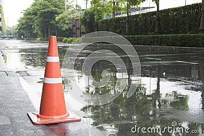 A traffic cone on the road in rain time and reflection Stock Photo