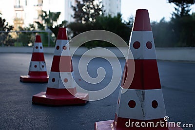 Traffic cones on road with electronic arrow pointing to the right to divert traffic and white car in distance Stock Photo