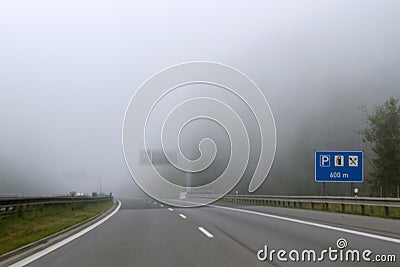 Car driving on highway in heavy fog. Traffic safety in heavy fog. Stock Photo