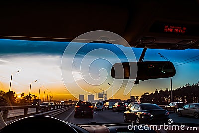 Traffic jams during rush hour on the way from work. the car goes in the rush hour. view inside the cabin. Colorful sunset in the Editorial Stock Photo