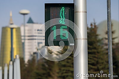Traffic light located within city limits shows green permissive signal for crosswalk traffic. Time timer shows remaining Stock Photo
