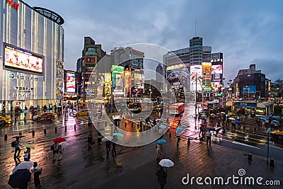 Traffic and people walking on crosswalk at Ximending with falling rain in Taipei, Taiwan. Ximending is the famous fashion, night Editorial Stock Photo
