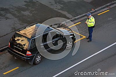 Traffic Police officer writing a traffic citation to a car drive Editorial Stock Photo