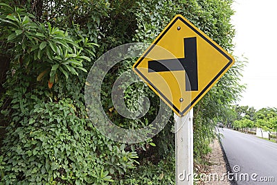 Traffic road sign yellow left intersections ahead. Stock Photo