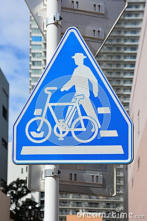 Traffic sign, blue pentagon pedestrian and bicycle sign on metal post with cityscapes background Stock Photo