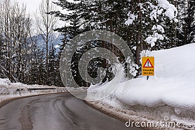 Red triangle road traffic warning sign - Other Danger. Crossroads with cross-country skis paths . Snow covered road, trees and mou Stock Photo