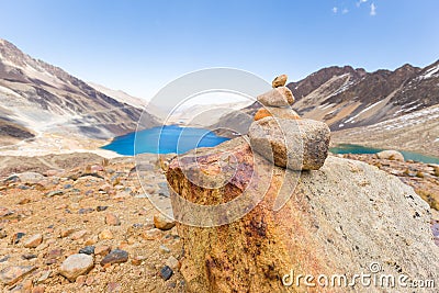 Trail cairn duck rocks pile sign mountains lake, travel Bolivia. Stock Photo