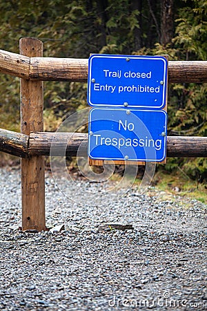 Trail closed. Entry prohibited. No trespassing. Sign posted on a fence to prevent the passage of persons and vehicles. Natural Stock Photo