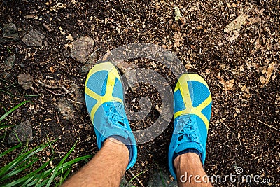 Trail runner looking down at sports shoe, running in nature Stock Photo