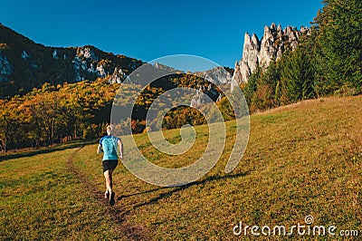 Trail runner train in beautiful autumn landscape. Carpathian forest and rocky hills in background Editorial Stock Photo