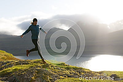 Trail runner running at the Faroe Islands above the fjord Editorial Stock Photo