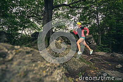 Trail running girl in green forest. Endurance sport. Stock Photo