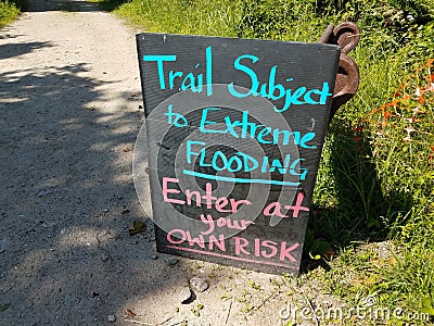 Trail subject to flooding enter at own risk sign Stock Photo