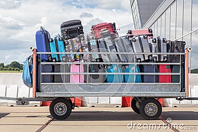 Trailer on airport filled with suitcases Stock Photo