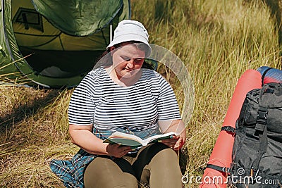 Trailside Tranquility Overweight Woman Hiking Haven with Book and Backpack Stock Photo