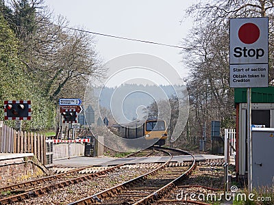Train approaching a Level Crossing in Devon UK Editorial Stock Photo