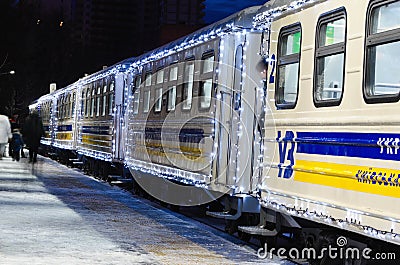 Train arrived at the station. The train cars decorated with Christmas garlands near the station platform Editorial Stock Photo