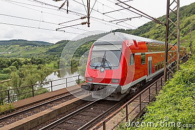 Train driving along german river Moselle Stock Photo