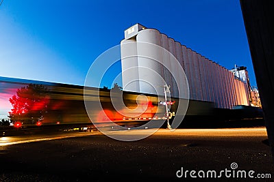 Train Moving Near Grain Silos Stock Photo