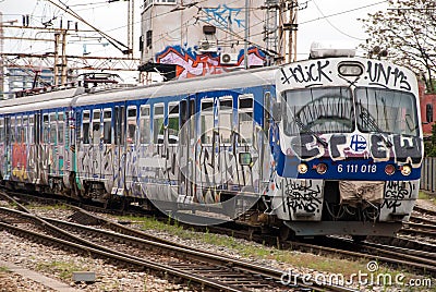 Train moving out of a station covered in graffiti in Zagreb, Croatia Editorial Stock Photo