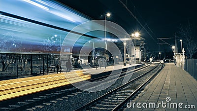 The train passed a railway station, people are waiting on the platform for the next train Stock Photo