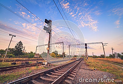 Train platform and traffic light at sunset. Railroad. Railway st Stock Photo