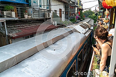 Train running on railway road with tourist watching the train from railway cafe in Hanoi, Vietnam Editorial Stock Photo