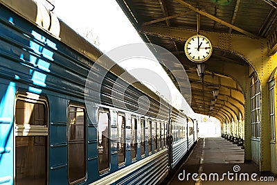 The train stands on the station platform. Station clock. Stock Photo