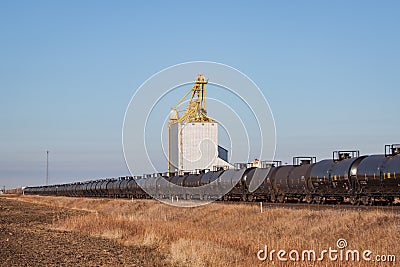 Train of Tank Cars Passing Grain Elevator Stock Photo