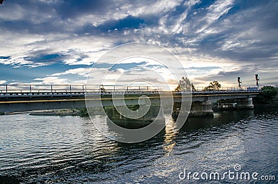 Train track bridge crossing a canal with dramatic cloudy sky in Rural area of Australia. Editorial Stock Photo