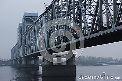 The train is traveling over a bridge over a river in thick fog. Gray background, color photo. Mystical picture Stock Photo