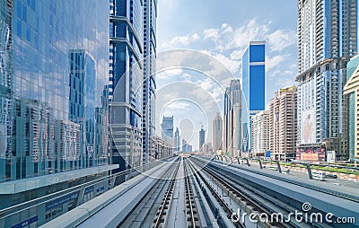 Train view on railway in Dubai Downtown at financial district, skyscraper buildings in urban city, UAE. Transportation for Editorial Stock Photo