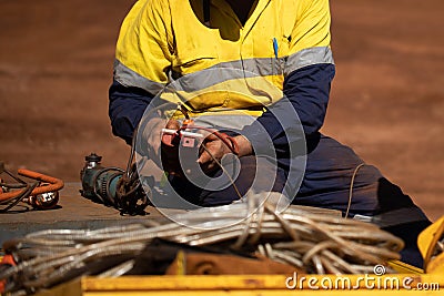 Trained competent electrician setting holding red electricity tester while conducting safety inspecting monthly tag Stock Photo