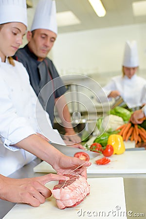 Trainee chef learning to tie joint meat Stock Photo