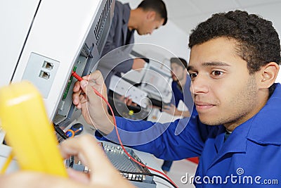 Trainee electricians learning their trade Stock Photo