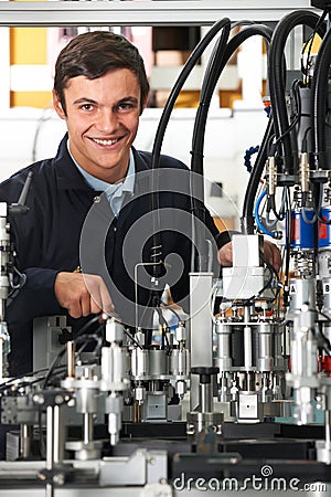 Trainee Engineer Working On Machinery In Factory Stock Photo