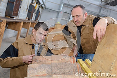 Trainee roofer learning how to tile roof properly Stock Photo