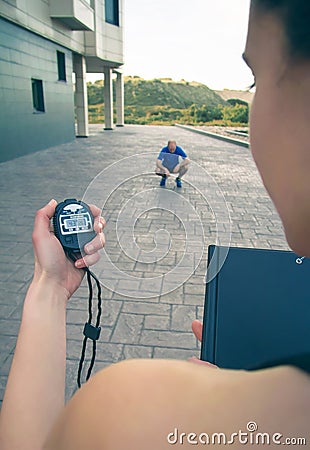 Trainer hand using chronometer to timing man Stock Photo