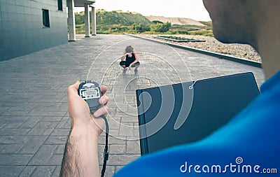 Trainer hand using chronometer to timing woman Stock Photo