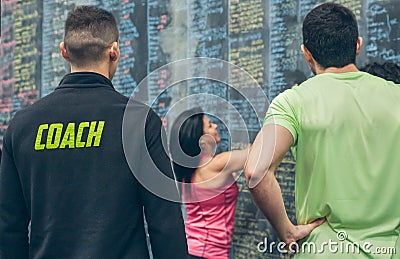 Trainer supervising female athlete writing down results on the gym blackboard Stock Photo