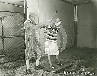 Trainer teaching woman to play golf Stock Photo