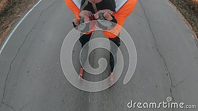 Training an athlete on the roller skaters. Biathlon ride on the roller skis with ski poles, in the helmet. Pov view Stock Photo