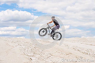 Training a bicyclist in a chalky quarry. A brutal man on a fat bike. Stock Photo