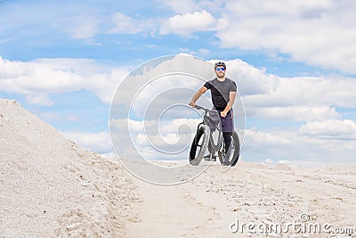 Training a bicyclist in a chalky quarry. A brutal man on a fat bike. Stock Photo